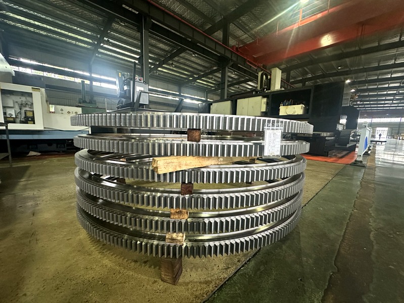 Stack of large-diameter slewing rings with external teeth ready for assembly Stack of large-diameter slewing rings with external teeth ready for assembly
